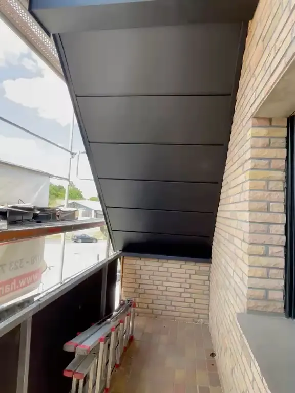 Mit Anthrazit-Blech verkleideter Dachüberstand über einem Balkon